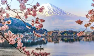 Wiosna na wyspach Japonii: kwitnące wiśnie, spokojne jezioro z łodzią i majestatyczny Fudżi.