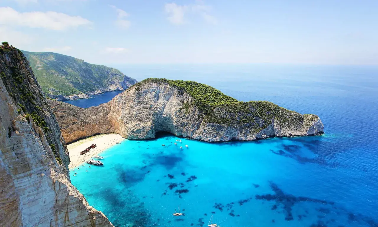Widok na Navagio Beach, jedną z najpiękniejszych plaż na wyspach greckich, z wrakiem statku i turkusową wodą.