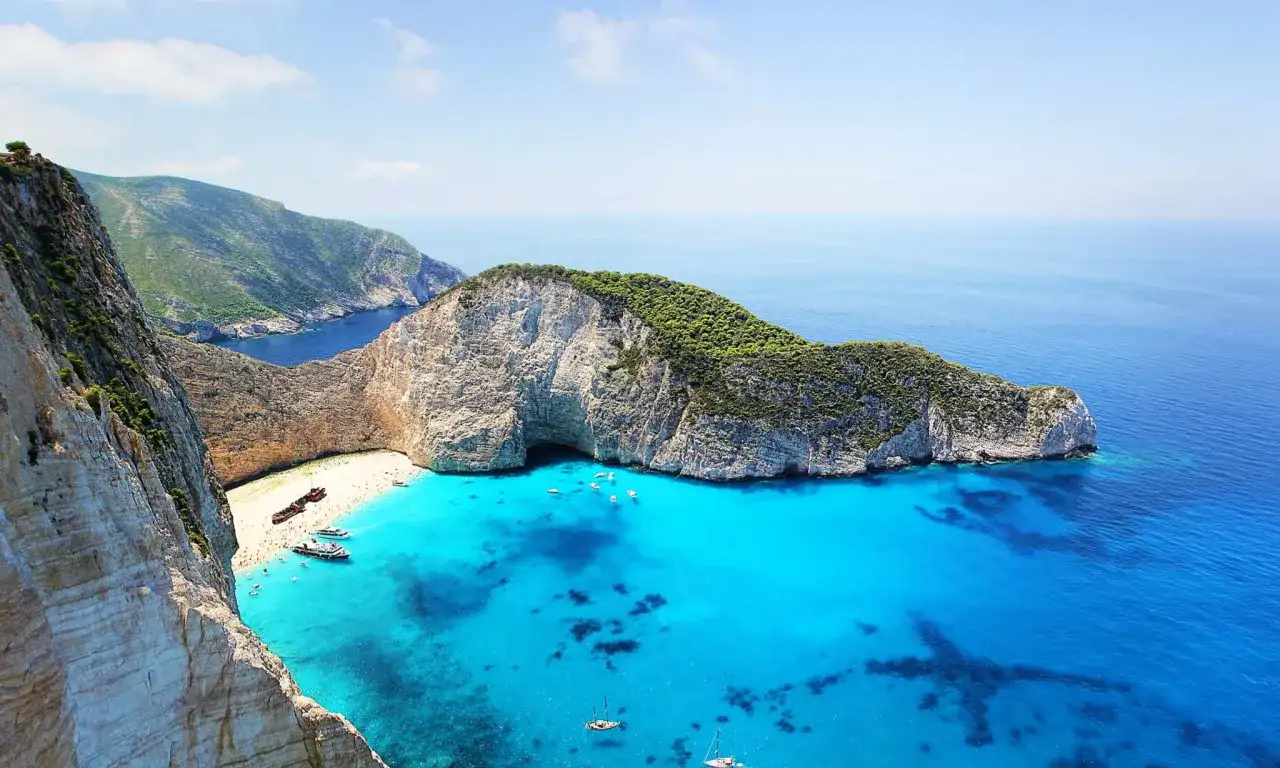 Widok na Navagio Beach, jedną z najpiękniejszych plaż na wyspach greckich, z wrakiem statku i turkusową wodą.