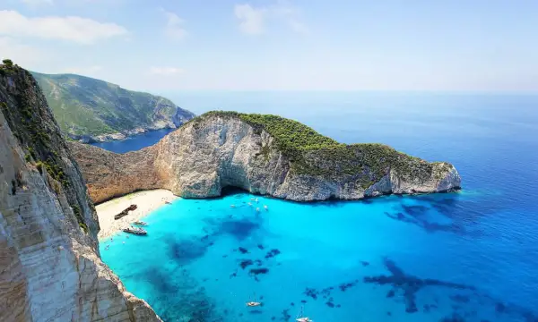 Widok na Navagio Beach, jedną z najpiękniejszych plaż na wyspach greckich, z wrakiem statku i turkusową wodą.