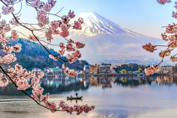 Wiosna na wyspach Japonii: kwitnące wiśnie, spokojne jezioro z łodzią i majestatyczny Fudżi.